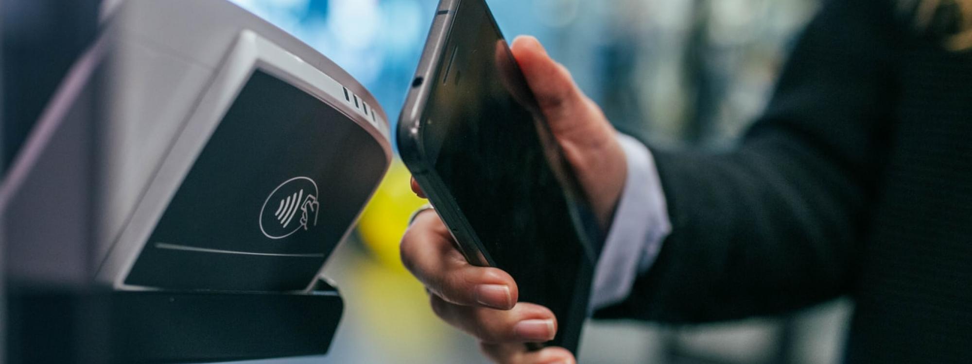 Mobile phone being used for payment at a tap and go machine