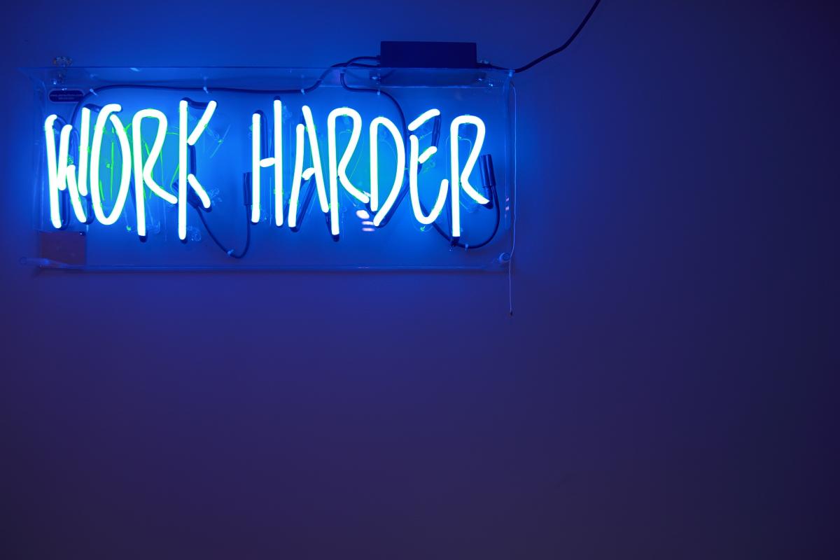 Neon sign saying Work Harder