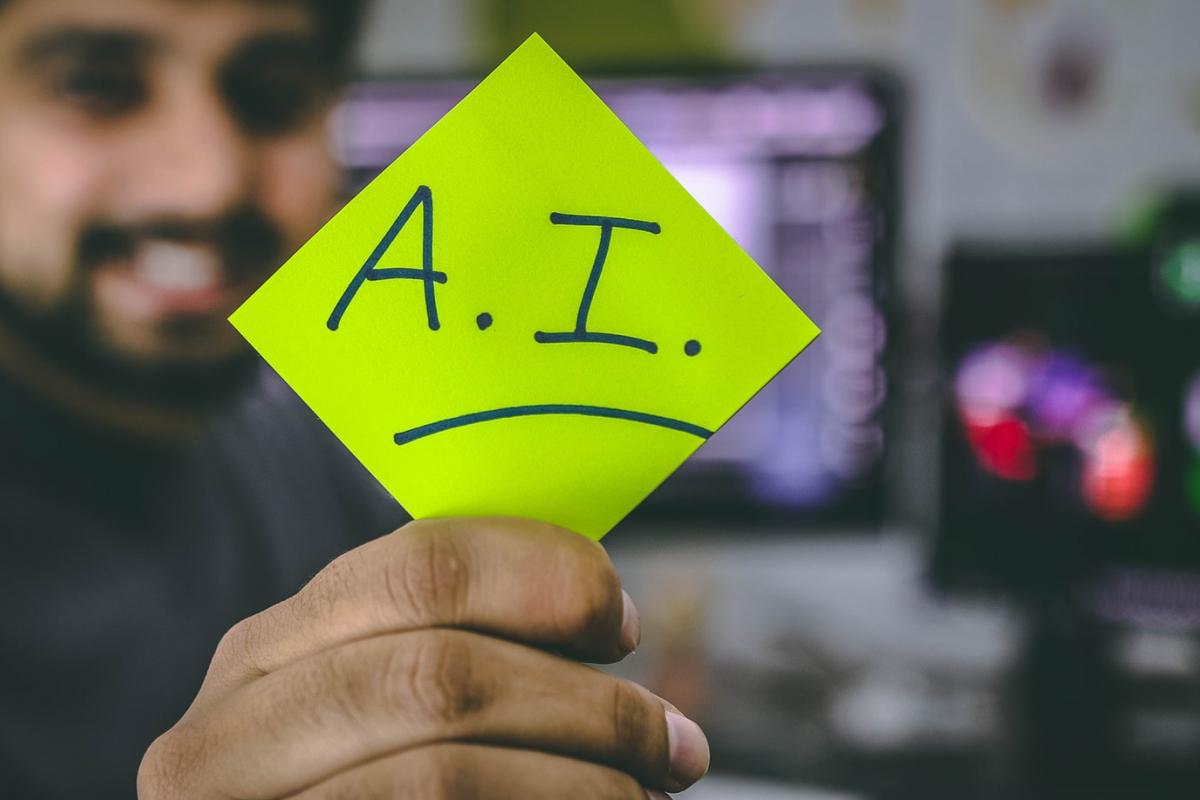 Man holding a post-it-note that says AI